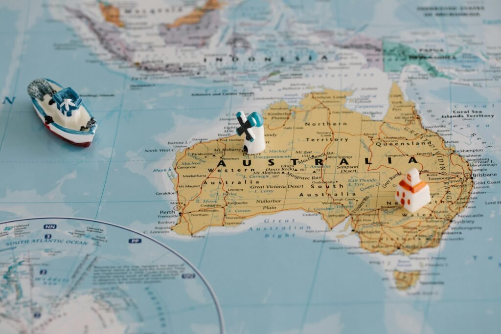 Miniature windmill and ship placed atop a map of Australia, highlighting travel concepts.